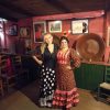 2 women wearing flamenco dresses in a traditional tablao in Seville, Spain