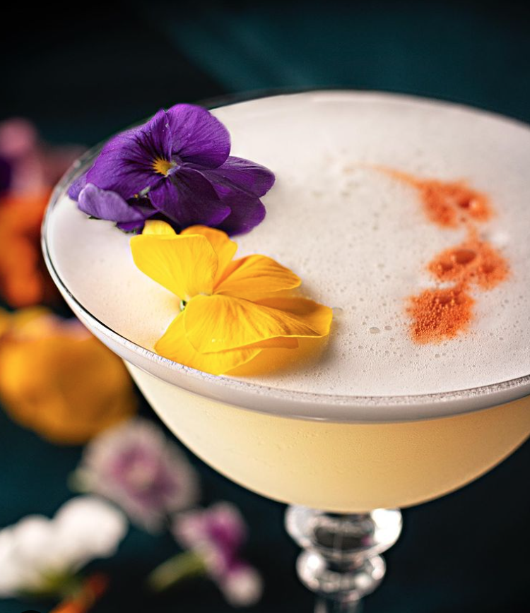Colourful Cocktail garnished with edible flowers. Photo from @thesecondroom