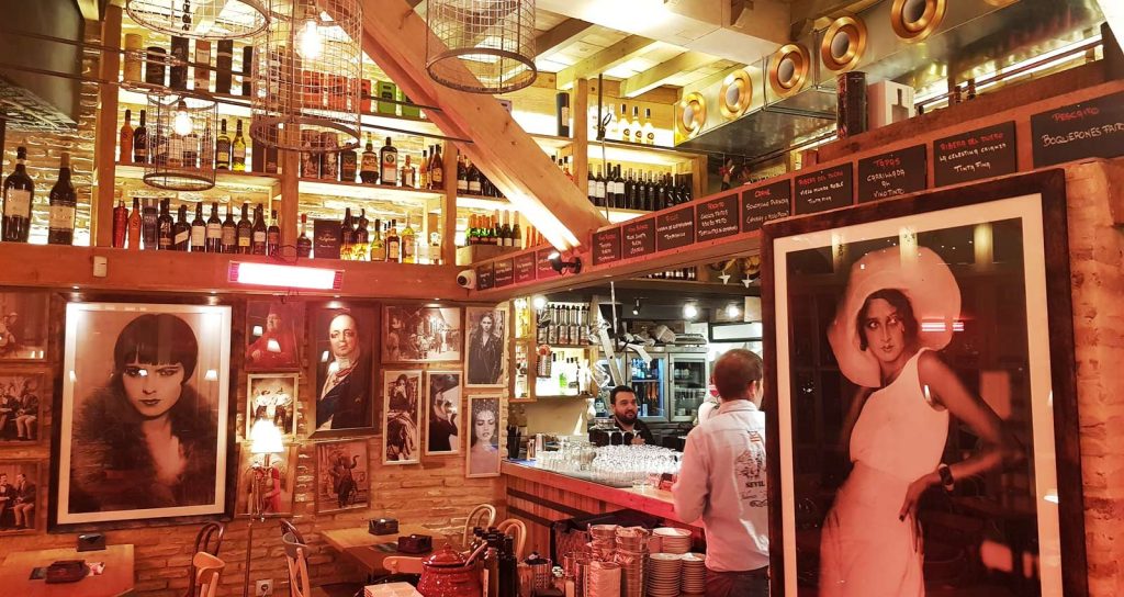 Wooden Bar with brick walls and large photographs of women