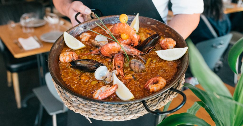 Seafood paella with mussels, prawns, clams and lemon wedges. 